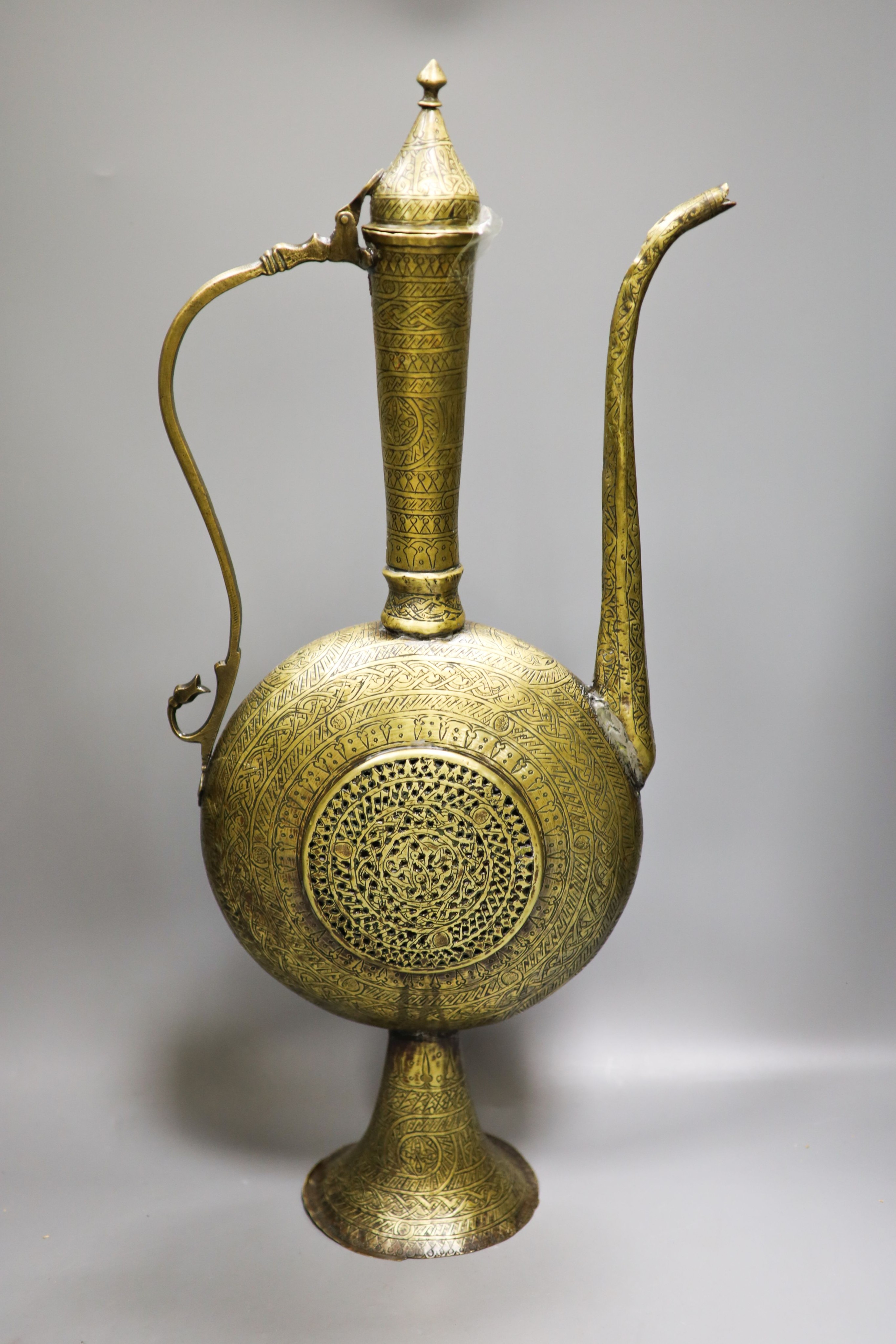 A Persian engraved brass ewer and Middle-eastern horn and white metal priming shot flask 57cm